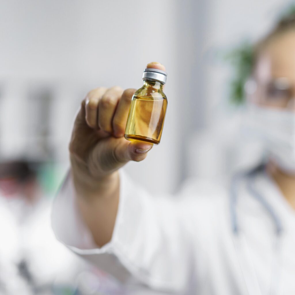 Cientista mostra um vidro com medicamento, representando o canabidiol.