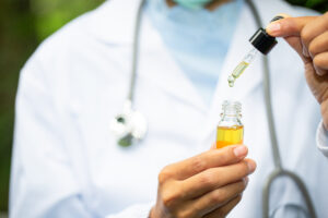 Médico mostra um medicamento em óleo, como o extrato de cannabis.