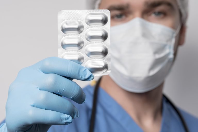 Médico segura uma cartela de remédios.